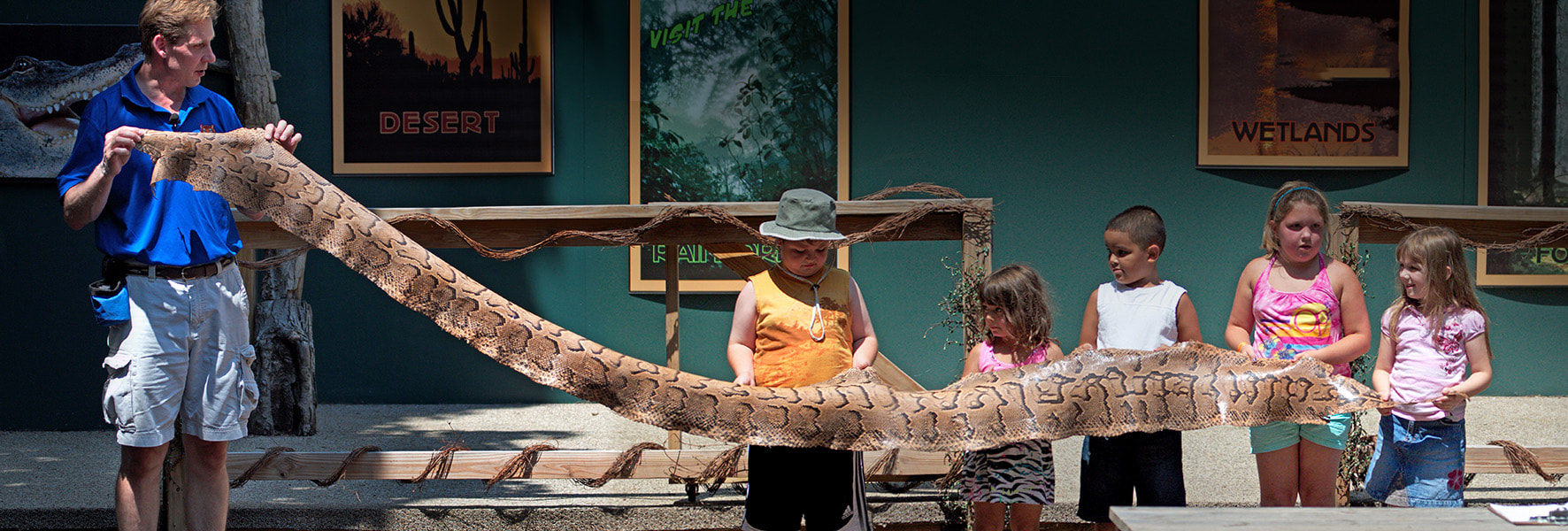 Children holding a long snake skin